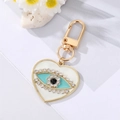 Detailed macro view of heart-shaped keychain with evil eye design and crystal inlay - White Heart White Crystal Eye