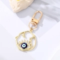 Vista detallada del llavero dorado con ojo azul turco y textura de ramas entrelazadas - Ojo Azul Oscuro Esmaltado Irregular