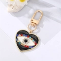 Macro shot of evil eye heart keychain with sparkling rhinestones and golden clip - Black Heart Colorful Crystal Eye