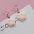 Close-up of cute cat paw drop earrings with pink pads on a decorative white card - White Pink Cat Paw