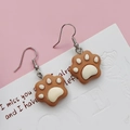Detail of cute brown resin cat paw earrings on a vintage style floral display card - Coffee