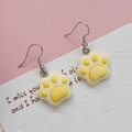 Detailed view of bicolor cat paw earrings featuring yellow pads and cream resin finish - Yellow Cat Paw