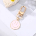 Detail eines rosa Emaille-Smiley-Schlüsselanhängers mit vergoldetem D-Ring-Karabiner - Rosa