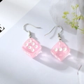 Macro view of pink translucent resin dice earrings with white dots and silver hooks - Pink