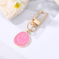 Schicker vergoldeter Smiley-Schlüsselanhänger mit rosa Emaille-Anhänger auf weiß - Rosarot