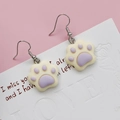 Close-up of cute 3D resin cat paw earrings with silver hooks and purple paw pads - Purple Cat Paw