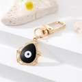 Detalle del llavero ojo turco dorado con esmalte negro y borde de encaje de metal fino - Gota de Agua Esmalte Negro (K200)