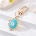 Detail of evil eye keychain with blue enamel inlay and ornate golden metal border finish - Oval Blue Enamel (K200)