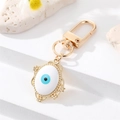 Detalle del llavero de ojo turco con marco de aleación dorada e iris de esmalte azul - Ovalado Esmalte Blanco (K200)