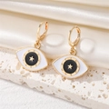 Detail of gold evil eye hoop earrings with white enamel and star motif on silk - Ear Buckle / Black