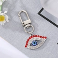 Silver Evil Eye keychain featuring red and white rhinestones with a blue resin eye center - Silver Red Eyelash Eye