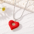 Collana retrò con ciondolo a cuore rosso traforato e catena a sfere d'argento su sfondo bianco - Rosso