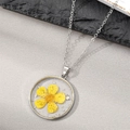 Macro detail of silver necklace with yellow dried flower preserved in clear resin - Yellow Five Petals