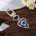 Evil eye keychain with blue bead and silver heart frame on a wooden base - Silver Heart Eye Charm