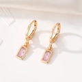 Close-up of gold-plated square pink crystal drop earrings on white textured fabric - Pink