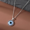 Classic silver evil eye pendant necklace with blue crystals on dark rock background - Evil Eye Necklace