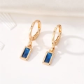 Macro detail of gold-plated geometric drop earrings with navy blue crystal stones - Blue