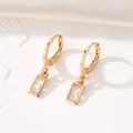 Elegant gold huggie hoop earrings with rectangular crystal pendant on white background - White