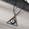 Close-up of vintage bronze triangle evil eye pendant on a black waxed cord necklace - Triangle Eye Necklace