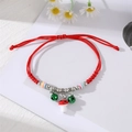 Detail of red braided bracelet with green bells, colorful beads and a cute mushroom charm - Green Bell Red Mushroom
