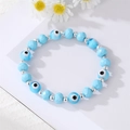 Sky blue beaded bracelet with Evil Eye charms and silver accents on white daisy background - Light Blue