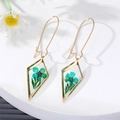 Detail of gold rhombus earrings with real blue dried flowers in clear resin - Green