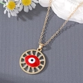 Vintage gold Evil Eye necklace with red enamel and crystals on dark texture background - Red