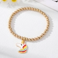 Detail view of a gold beaded elastic bracelet featuring a colorful unicorn enamel charm - Unicorn Bracelet