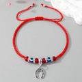 Macro shot of red braided string bracelet with evil eye beads and horseshoe charm - Horseshoe U-Shape Red String