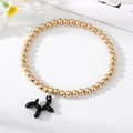 Bracciale a sfere dorate con ciondolo a forma di cane palloncino nero su sfondo bianco - Nero