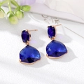 Macro shot of deep blue faceted crystal drop earrings with rose gold setting detail - Sapphire Blue