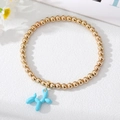 Dettaglio del bracciale a sfere dorate con ciondolo a forma di cane palloncino blu chiaro - Blu