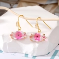 Elegantes pendientes de ojo de la suerte dorados con detalle rosa en rama de madera - Ojo Rosa
