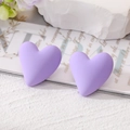 Matte lavender heart-shaped stud earrings in a romantic lifestyle setting on white stone - Purple