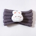 Macro detail of purple knit baby headband with a plush white cartoon bunny rabbit charm - Gray