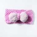 Close-up of pink knitted baby headband featuring a purple bow with floral embroidery - Pink