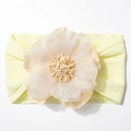 Détail du bandeau jacquard pour bébé avec fleur jaune et texture de maille tricotée - Beige