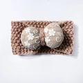 Detailed knit texture of khaki winter headband featuring a white floral bow embroidery - Coffee