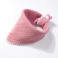 Detailed view of pink muslin cotton baby bib with white pom-pom trim and snap closure - Dust Rose