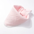 Detailed view of pink cotton baby bib with pom-pom trim and snap button closure - Light Pink