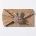 Close-up of a camel knitted baby headband with a cute plush rabbit embroidery decoration - Brown