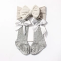 Detailansicht grauer Babystrickstiefel mit Satinschleifen und beige Stirnband-Set - Grau