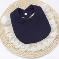 Detail shot of navy blue waffle cotton baby bib with floral lace trim and snap closure - Navy Blue