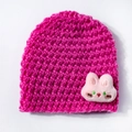 Detail of hot pink knit baby beanie featuring a soft plush rabbit patch with embroidery - Rose Red