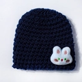 Close-up of dark blue knit baby hat featuring a soft white plush bunny patch detail - Navy Blue