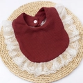 Detail of burgundy waffle cotton baby bib with delicate white lace trim and snap button - Burgundy