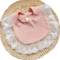 Close-up of pink cotton waffle bib featuring delicate white floral lace edges and snap button - Nude Pink