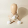 Dettaglio di sciarpa neonato in maglia con testa di coniglio e pompon bianchi - Beige
