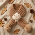 Detailed view of children's knit bear scarf with fuzzy pom-poms on rustic autumn background - 80cm / Coffee