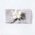 Close-up of knit baby headband featuring a large 3D flower and soft warm wool texture - Beige